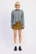 Person wearing a striped sweater, brown shorts, and black shoes on a white background