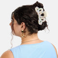 Person with a white hair clip in their bun against a white background