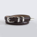 Brown leather belt with silver buckle and spike on a light gray background
