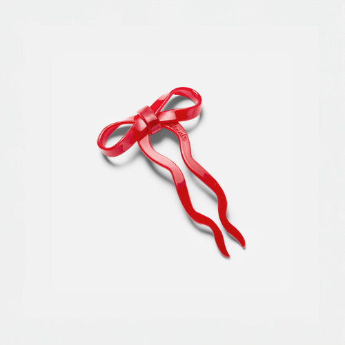 Red hair bow on a light gray background