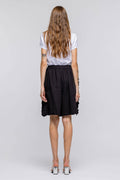 Person wearing a white t-shirt and black skirt on a plain background