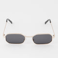 Sunglasses with gold frame and dark lenses on a white background