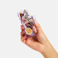 Hand holding a clear phone case with beach-themed decorations on a white background