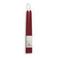 Two red candles with a white label on a white background