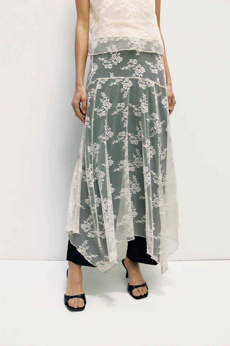 Long floral skirt with a white top on a plain background