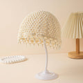 Decorative table lamp with pearl-like bead embellishments on a beige background