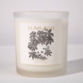 Frosted candle with floral design and 'Teak Ash' text on a white background