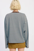 Person wearing a striped sweater and mustard skirt on a white background