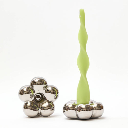 Green silicone tool with metal components on a white background