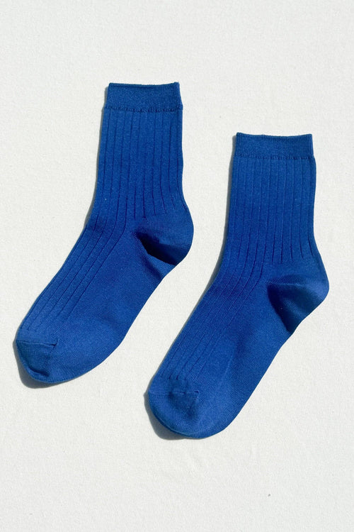 Pair of blue socks on a light gray background