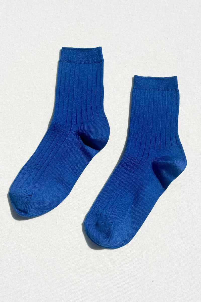 Pair of blue socks on a light gray background