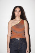 Woman wearing a one-shoulder striped top and dark jeans against a white background