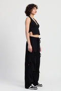 Woman wearing a black halter top and wide-leg pants on a white background