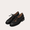 Black lace-up shoes on a light gray background