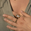 woman wearing Gold ring with a central blue gemstone 
