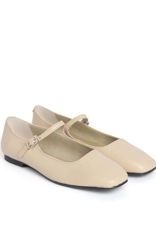 Pair of beige shoes with a strap on a white background