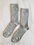 Pair of gray socks on a light beige background