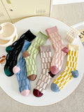 Set of colorful socks on a round white table with a neutral background