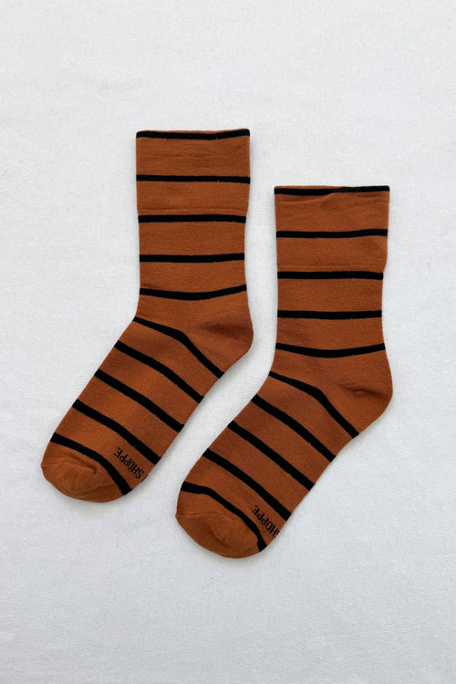Pair of brown socks with black stripes on a white background