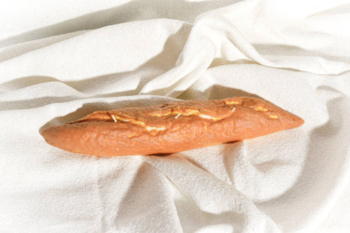 Long rectangular bread roll on a white fabric background