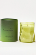 Green candle and its packaging on a white background