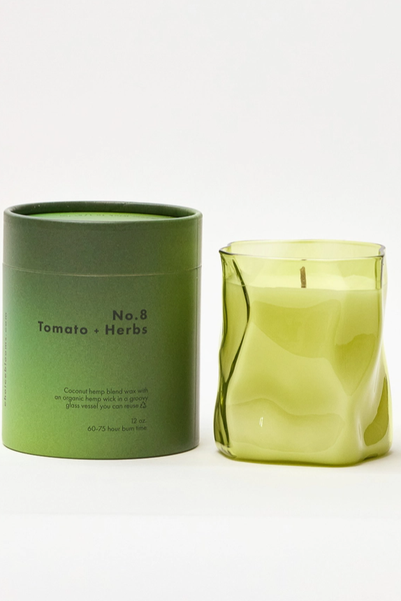 Green candle and its packaging on a white background