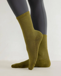 Green socks worn with gray tights on a white background