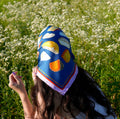 Person wearing a decorative headscarf with a classical painting design on a flower background