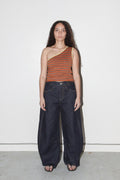 Woman wearing a striped top and dark jeans against a white background