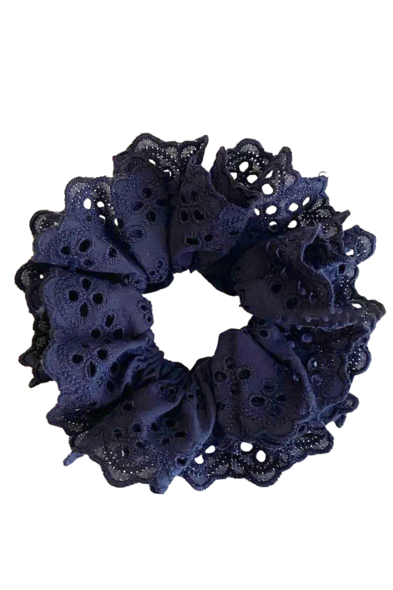 A black eyelet fabric scrunchie with ruffled edges, shown against a plain white background.