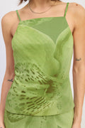 Green tank top with floral design worn by a person on a white background