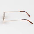 Eyeglasses with a gold frame and tortoiseshell arms on a white background
