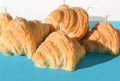 Croissant-shaped candles on a blue surface