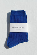 Pair of blue socks with a white label on a light gray background