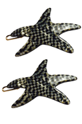 Two starfish-shaped hair claw clips with a black and white checkered pattern and gold-tone metal clasps, shown on a plain white background.