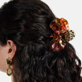 Close-up of a tortoiseshell hair clip on dark hair with a white background