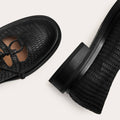 Black textured shoes and belt on a white background