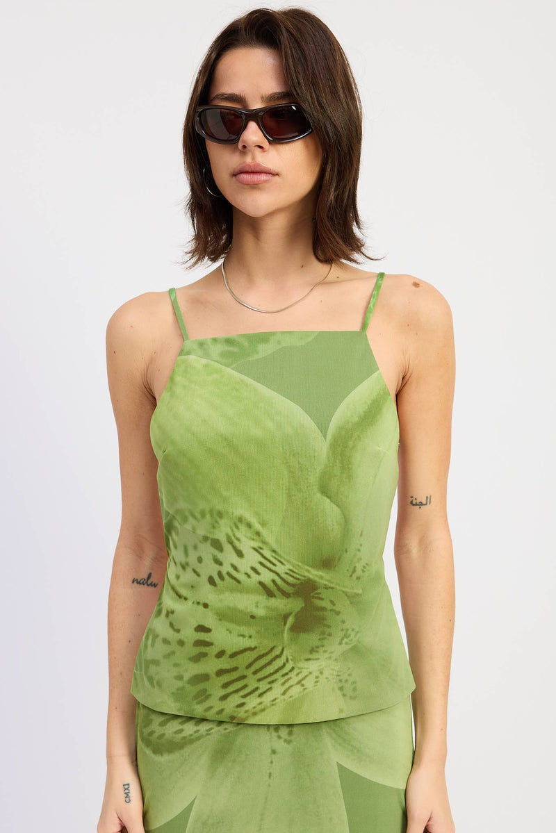 Woman wearing a green tank top with a subtle pattern on a white background