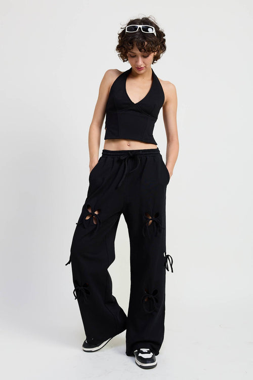 Woman wearing a black outfit with distressed details on a white background